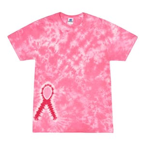 May include: Pink tie-dye t-shirt with a red ribbon design on the left side. The shirt is made of a soft, comfortable material and is perfect for showing support for breast cancer awareness.