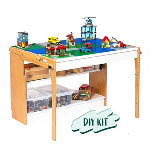 May include: A wooden play table with a white top and two shelves. The table is set up with a Lego city scene, including buildings, vehicles, and a helicopter. The words "DIY KIT" are in a green and white banner.
