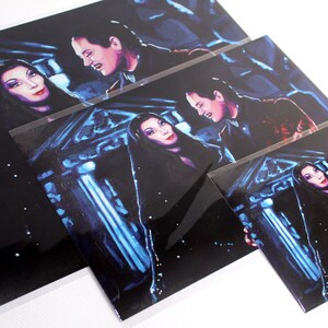 K&ouml;nnte beinhalten: Ein Set aus drei Drucken mit Figuren aus der Addams Family. Die Drucke sind in einem dunklen, stimmungsvollen Stil mit einem blauen und violetten Farbschema gehalten. Die Figuren sind in einer dramatischen Pose dargestellt, wobei die Frau in der Mitte ein schwarzes Kleid und eine lange, dunkle Per&uuml;cke tr&auml;gt.