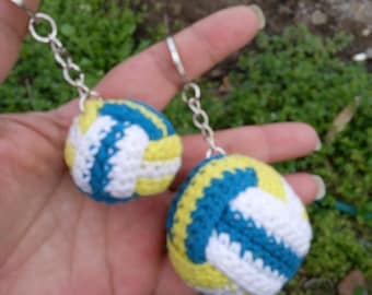 May include: Two crocheted volleyball keychains, one with yellow and blue stripes and the other with yellow and white stripes.