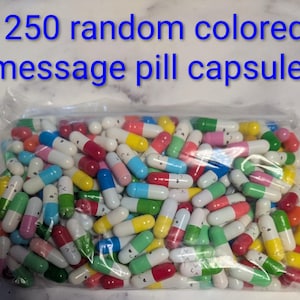 May include: A clear plastic bag filled with 250 random colored message pill capsules. The capsules are in various colors, including white, red, pink, blue, green, and yellow. Each capsule has a smiling face design.