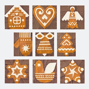 May include: A collection of nine gingerbread-style Christmas ornaments. Each ornament is a different shape, including a house, heart, angel, mitten, bell, Christmas tree, star, bird, and another star. The ornaments are brown with white accents and are set against a brown background.