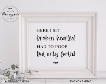 May include: A white framed print with the text "HERE I SIT broken hearted HAD TO POOP but only farted" in black lettering. The print is sitting on a white surface with green plants in the foreground.