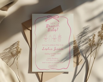 May include: A baby shower invitation with pink text and a pink border. The invitation reads "Let's Brunch Baby!" and includes details for the event, such as the date, time, and location. The invitation is on a cream-colored card.