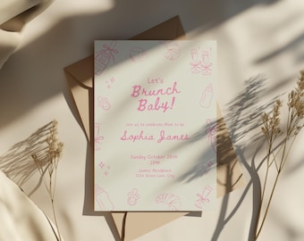 May include: A baby shower invitation with the text "Let's Brunch Baby!" in pink script. The invitation is decorated with pink line drawings of baby bottles, champagne flutes, and croissants. The invitation is on a cream-colored background.