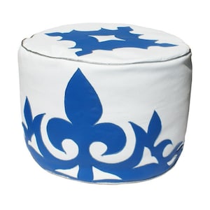 Könnte beinhalten: Weißer Lederhocker mit blauem Blumendesign. Der Hocker ist rund und hat eine weiße Oberseite mit einem blauen Blumendesign um die Unterseite.
