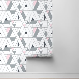 Puede incluir: Un rollo de papel tapiz blanco con un patrón geométrico de triángulos rosas, grises y negros.