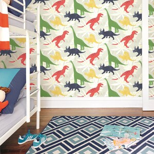 May include: A white bunk bed with a red and white striped blanket and a blue pillow. The wall behind the bed is covered in a wallpaper with a repeating pattern of green, red, yellow, and blue dinosaurs.