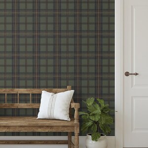 May include: A room interior featuring a wooden bench with a white pillow, a potted plant, and a white door. The wall is covered in a green, brown, and blue plaid wallpaper. The floor is made of light-colored wood.