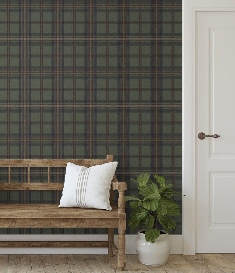 May include: A room interior featuring a wooden bench with a white pillow, a potted plant, and a white door. The wall is covered in a green, brown, and blue plaid wallpaper. The floor is made of light-colored wood.