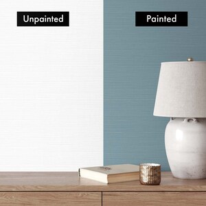 May include: A side-by-side comparison of two walls, one unpainted and one painted a light blue color. The painted wall has a lamp and a book on a wooden table.