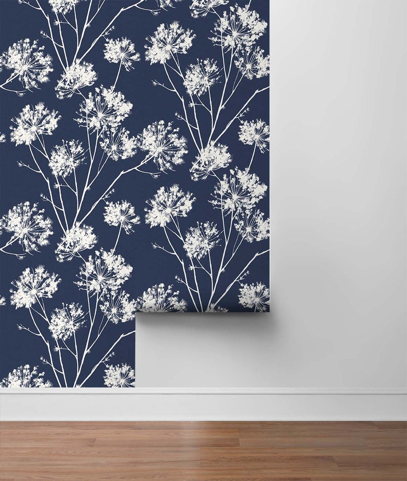 May include: A roll of navy blue wallpaper with a white floral pattern. The wallpaper has a repeating pattern of white flowers on a dark blue background.