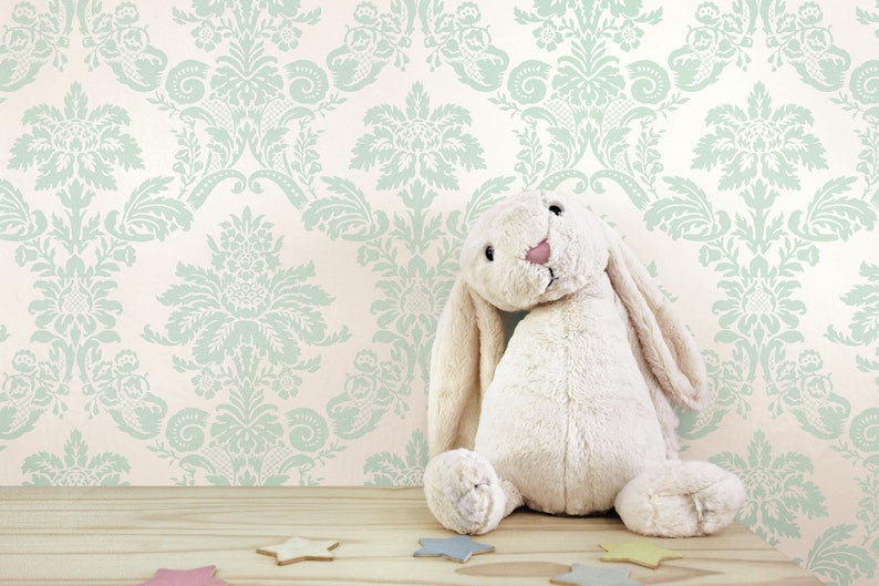 May include: A white plush bunny rabbit toy sitting on a wooden surface with a light green and white damask patterned wallpaper in the background.