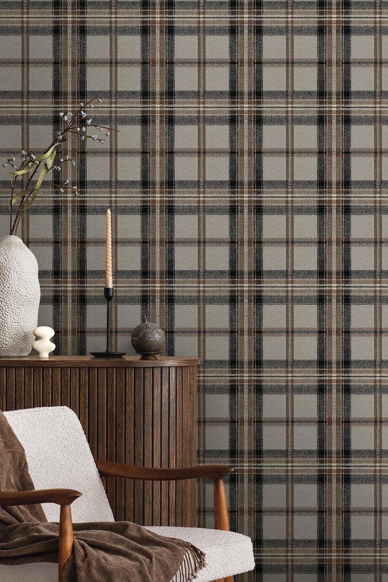 May include: A neutral-toned plaid wallpaper with a repeating pattern of gray, black, and brown lines. The wallpaper is displayed behind a wooden cabinet, a white chair, and decorative items, creating a cozy interior design scene.