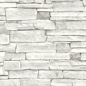 May include: A white stone wall with a rough, textured surface. The wall is made up of various sized stones, creating a rustic and natural look.