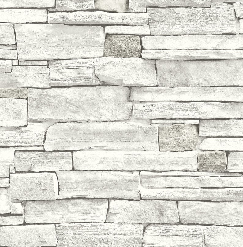 May include: A white stone wall with a rough, textured surface. The wall is made up of various sized stones, creating a rustic and natural look.