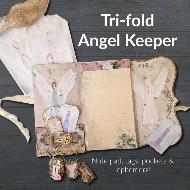 May include: Tri-fold Angel Keeper note pad with tags, pockets, and ephemera. The cover features a vintage design with angels and floral accents.
