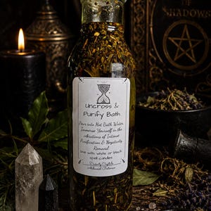 Puede incluir: Una botella de vidrio transparente llena de una mezcla de hierbas oscuras, con una tapa negra. La etiqueta blanca presenta un icono de reloj de arena y el texto: Uncross & Purify Bath, Pour into Hot Bath Water, Immerse Yourself in the vibrations of Intense Purification & Negativity Removal, Use with white or black spell candles, Divinity Crystals, Alchemist Botanica.
