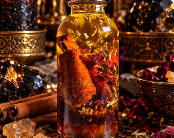 May include: A clear glass bottle with a black screw-top lid filled with a golden liquid, a large cinnamon stick, and scattered dried herbs and red flower petals. The bottle is positioned upright, showcasing the botanical contents inside.