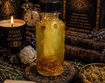 May include: A clear glass bottle with a black cap containing a yellow liquid and dried botanical elements. The bottle sits on a circular decorative base, surrounded by an open book with the text Today's Focus, Clarity, Discipline, Purpose, Powerful Mind, I am alert, I am focused, I accomplish with ease.