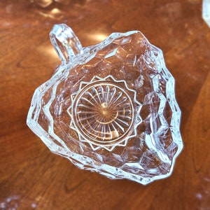 K&ouml;nnte beinhalten: Eine klare Glassch&uuml;ssel mit Diamantmuster und einem Griff. Die Sch&uuml;ssel hat ein dekoratives, kreisf&ouml;rmiges Design in der Mitte.