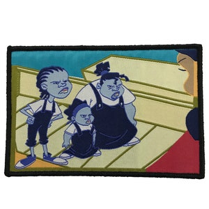 Puede incluir: Parche bordado con tres personajes de dibujos animados con monos azules y camisas blancas, con expresiones serias. El parche tiene un borde negro y un fondo azul claro y beige.