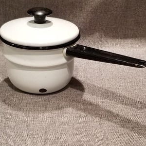 May include: White enamel double boiler with a black handle. The pot has a black rim and a black knob on the lid.