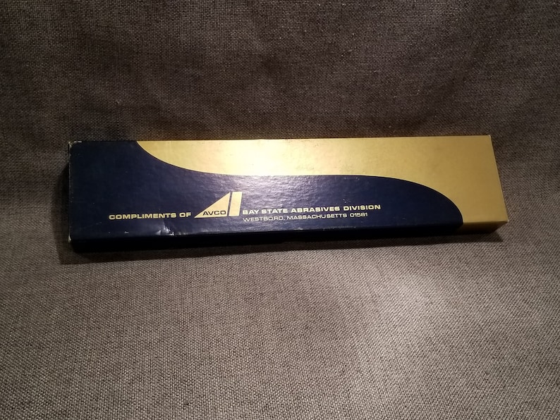 May include: A blue and gold box with the text "Compliments of AVCO Bay State Abrasives Division Westboro, Massachusetts 01581" printed on it.