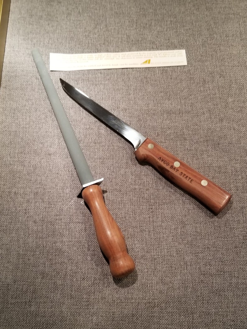 May include: A gray sharpening steel with a wooden handle and a silver knife with a wooden handle that says "W.R. CASE & SONS  BRADFORD, PA.  U.S.A.  O-BAY STATE"