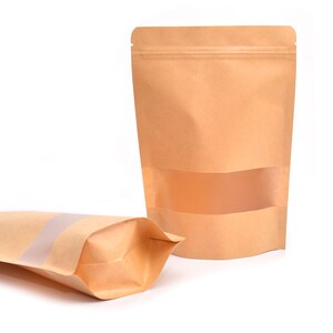 May include: Two brown paper bags with a clear window. The bags have a zipper closure and are standing upright on a white background.
