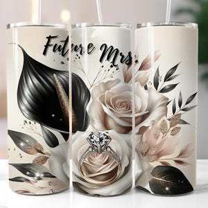 May include: A beige tumbler with a floral design featuring a black calla lily, white and beige roses, and a diamond ring. The words "Future Mrs." are written in black script.