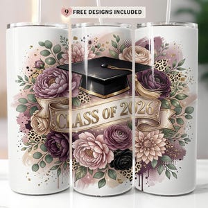 May include: A white tumbler featuring a graduation cap, floral arrangement, and the text "CLASS OF 2026." The design includes pink, purple, and gold accents, with a banner and leopard print details. The top of the tumbler has a straw.