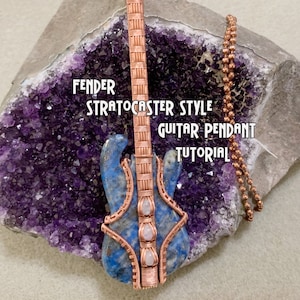 Peut inclure: Pendentif de guitare en fil de cuivre enroulé avec un corps en lapis-lazuli et des accents de pierres blanches. Le pendentif est sur une chaîne en cuivre et repose sur une géode d'améthyste violette. Le texte "Fender Stratocaster Style Guitar Pendant Tutorial" est visible sur la géode.