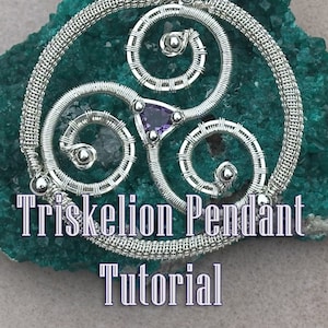Può includere: Un ciondolo Triskelion in filo d'argento con una pietra preziosa viola al centro. Il ciondolo è su uno sfondo di roccia verde. Il testo "Triskelion Pendant Tutorial" è sotto il ciondolo.