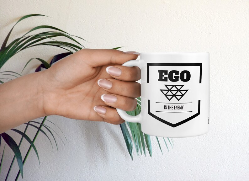 May include: White ceramic mug with a black graphic that says "Ego is the enemy".