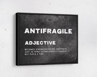 May include: Black and white typography print on a textured canvas with a black frame. The print reads "ANTIFRAGILE ADJECTIVE BECOMES STRONGER FACING ADVERSITY. JUST AS WIND EXTINGUISHES A CANDLE. BUT FUELS A FIRE."