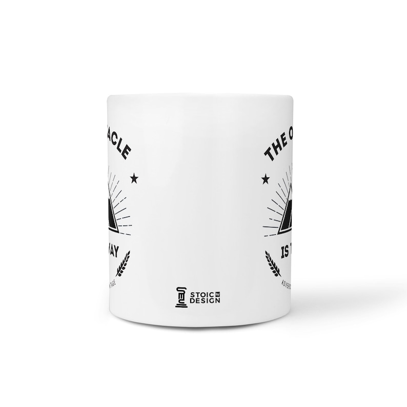 May include: White ceramic mug with black text and graphic. The text reads "The Obstacle Is The Way" and features a mountain with a star on each side. The text "Stoic Design" is printed on the bottom of the mug.