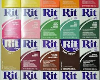 Puede incluir: Una colección de paquetes de tinte Rit en varios colores, incluyendo rojo, naranja, amarillo, verde, azul, morado, marrón y negro. Cada paquete presenta el logotipo de Rit y el nombre del color del tinte.