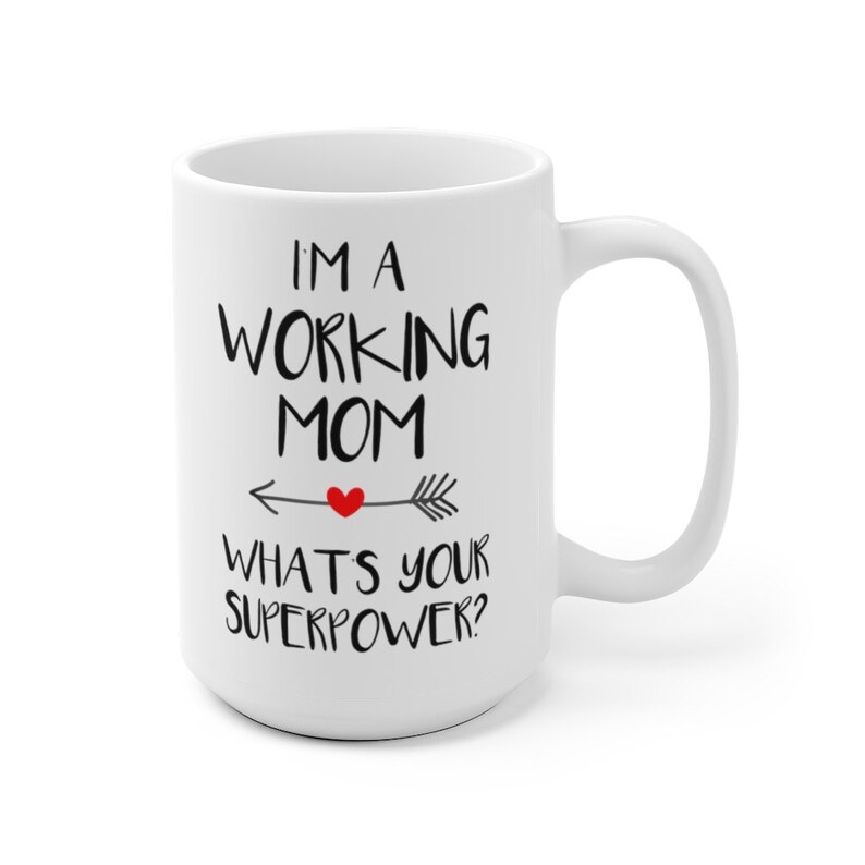 Puede incluir: Taza de cer&aacute;mica blanca con el texto "I'M A WORKING MOM WHAT'S YOUR SUPERPOWER?" en letras negras. Un coraz&oacute;n rojo est&aacute; en el centro de un dise&ntilde;o de flecha. La taza tiene un asa grande.