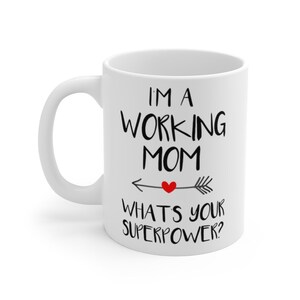 Puede incluir: Taza de cer&aacute;mica blanca con texto negro. La taza presenta el texto "I'M A WORKING MOM" con una flecha y un coraz&oacute;n, y el texto "WHAT'S YOUR SUPERPOWER?"