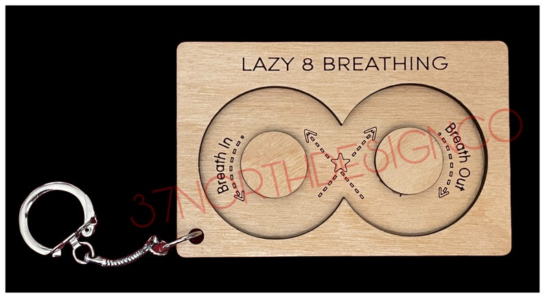 May include: Wooden keychain with a Lazy 8 Breathing design. The keychain features two circles connected by a figure eight shape, with arrows indicating the direction of breath in and out.