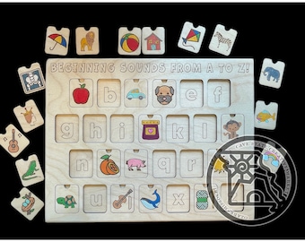 May include: Wooden alphabet puzzle with removable picture tiles. The puzzle board has the text "BEGINNING SOUNDS FROM A TO Z!". Each tile features a letter and a corresponding image, such as an apple, car, and dog.