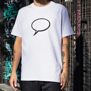 May include: White crew neck t-shirt featuring a black speech bubble graphic. The t-shirt is made of a soft material and is suitable for casual wear. The design is simple and modern, perfect for everyday outfits.