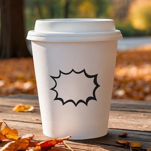 Könnte beinhalten: Ein weißer Pappbecher mit Deckel, verziert mit einem schwarzen Sprechblasen-Design. Der Becher steht auf einer Holzoberfläche mit Herbstlaub, was ein herbstliches Thema suggeriert. Der Hintergrund ist verschwommen, mit Bäumen und Blättern.