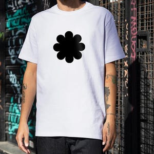 Könnte beinhalten: Weißes T-Shirt mit einem großen schwarzen Blumenmuster. Das kurzärmelige Oberteil ist aus einem weichen Stoff gefertigt und eignet sich für Freizeitkleidung. Das Blumenmuster ist mittig auf der Brust platziert.