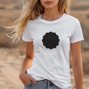 Könnte beinhalten: Weißes T-Shirt mit Rundhalsausschnitt und großem schwarzem, wellenförmigem Design auf der Vorderseite. Das T-Shirt besteht aus einem weichen Material und eignet sich für Freizeitkleidung. Das Model trägt blaue Jeans.