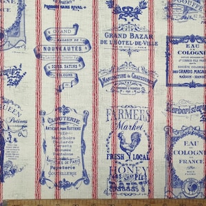 May include: A white fabric with red and blue stripes featuring a repeating pattern of vintage French-style labels and text. The labels are in blue and feature text such as "Grand Bazar", "Farmers Market", "Cloterie", "Eau de Cologne", and "Cacao Payrau".