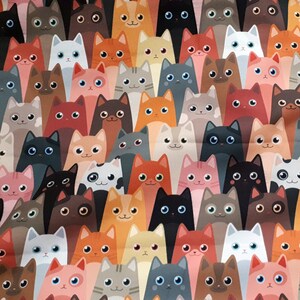 May include: A colorful fabric with a repeating pattern of cartoon cats in various colors and poses. The cats are all looking at the viewer.