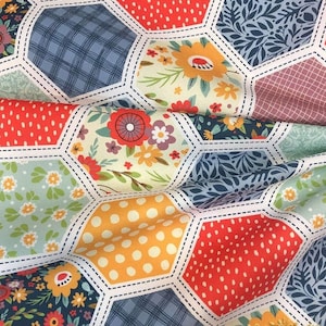 K&ouml;nnte beinhalten: Ein Patchwork-Stoff mit einem sechseckigen Muster. Der Stoff zeigt eine Vielzahl von floralen, geometrischen und gepunkteten Designs in Rot-, Blau-, Gr&uuml;n-, Gelb- und Wei&szlig;t&ouml;nen.
