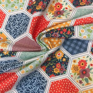 K&ouml;nnte beinhalten: Ein Patchwork-Stoff mit einem sechseckigen Muster. Der Stoff zeigt verschiedene Blumenmuster in Rot-, Gelb-, Blau- und Gr&uuml;nt&ouml;nen. Der Stoff ist perfekt zum Quilten, Basteln und f&uuml;r andere N&auml;hprojekte.